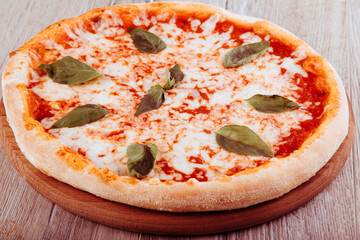 pizza margarita on wooden background top view