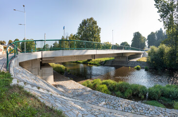 A new bridge across a small river. Summer time. 
Small reinforced concrete bridge after reconstruction. New asphalt.