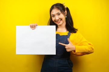 Obraz na płótnie Canvas Pretty and cute young woman cheerful holding blank empty banner, placard, white board, blank sign board, white advertisement board, presenting something in copy space, promotion
