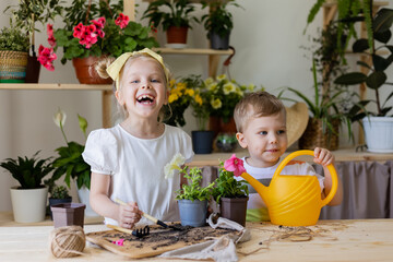 a boy and a blonde girl brother and sister of European appearance plant and transplant and water...