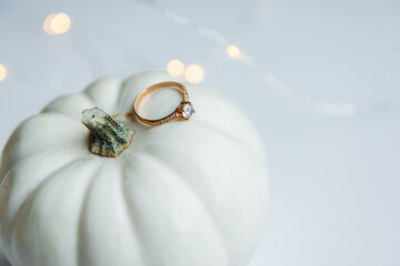 Autumn wedding. There is an engagement ring on the white pumpkin. White isolated background
