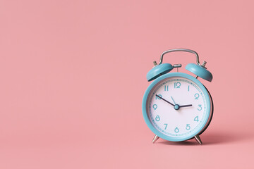 Alarm clock. Classic watch on a pink background.