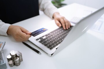 Woman holding credit card and using laptop computer for Internet online e-commerce shopping spending money Online shopping laptop technology concept . Online shopping pay by credit card concept