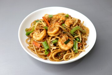 Chinese cuisine, Prawns Chilli garlic noodles. Stir fry noodles with vegetables and shrimp. served in a white plate. Hakka noodles With copy space.