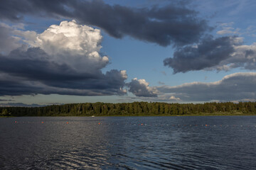 Cloudy sky over the river in the evening. Picturesque landscape with clouds and a river.
