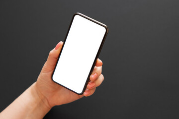 Person holding phone in hand on dark background