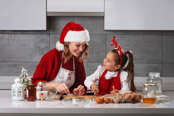 Mother and daughter making Christmas cookies in the kitchen 