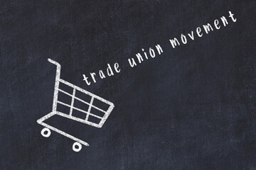 Chalk drawing of shopping cart and word trade union movement on black chalboard. Concept of...
