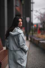 Portrait of brunette woman in the business downtown of modern city. Girl with long hair turn around and looking in camera. Business woman with trafic city lights in the background.