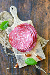 Slices Of  Traditional Italian  dried thinly sliced   artisan  pork salami Milano .Antipasti  salami on a wooden  cutting board © Striker777