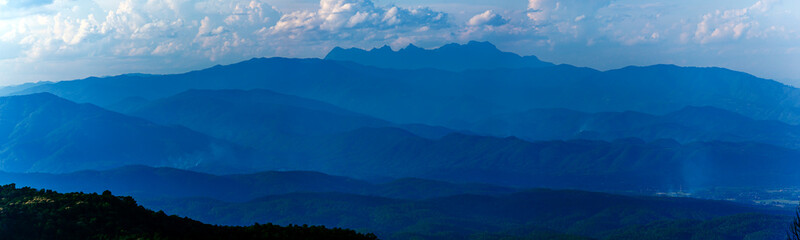 Majestic sunset sky over blue mountains landscape in cloudy day of rainy season