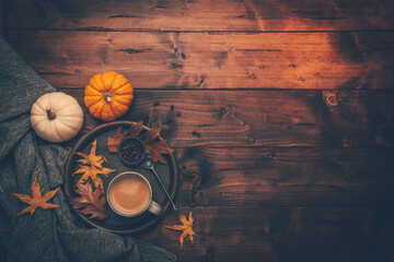 Autumn flatlay with cup of coffee, pumpkins and cuddle blanket
