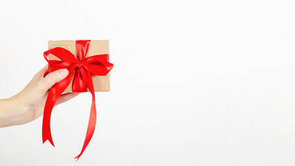 Female hand holds a gift box on a white background. Holiday and shopping concept. Christmas, Valentine's Day, Mother's Day, Women's Day