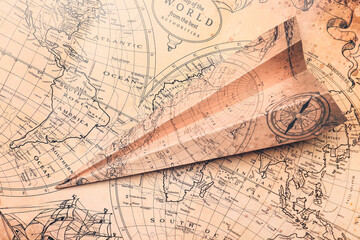 Paper airplane on vintage world map