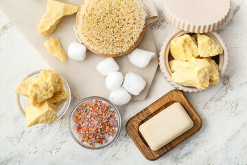 Composition with cocoa butter and bath supplies on light background