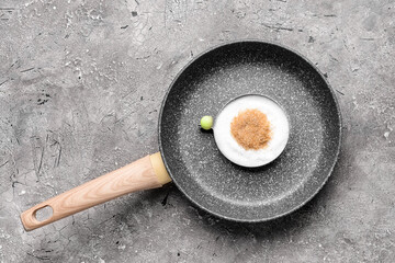 Frying pan with egg made of sugar on grunge background