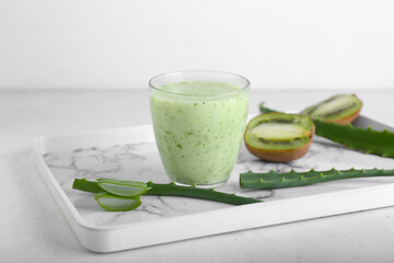 Tray with glass of healthy aloe juice on white background