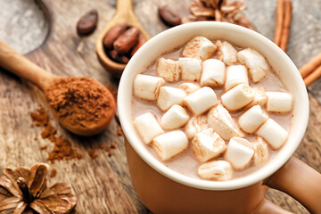 Wooden board with cup of hot cocoa drink on table, closeup