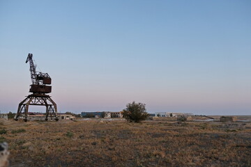 Fototapeta na wymiar Aralsk, Kazakhstan - 10.04.2020 : The old metal structure of the destroyed port on the Aral Sea