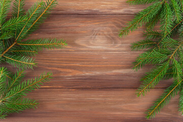 Fir branches on a wooden background. Christmas and New Year concept. Horizontal orientation, copy space, top view.