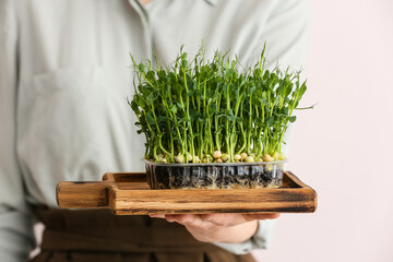 Woman with fresh micro green on white background