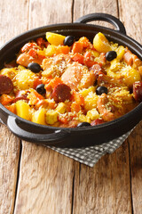 Chinese Galinha a Portuguesa chicken stew with vegetables in coconut curry close-up in a frying pan on the table. Vertical