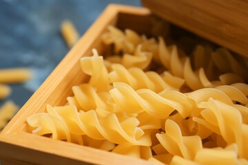 Uncooked fusilli pasta in wooden box