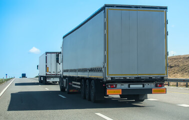 Obraz na płótnie Canvas Trucks move along a suburban highway