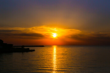 Fototapeta na wymiar sunset in the cloudy sky over the sea