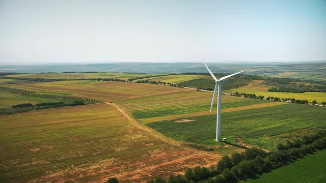 Aerial drone view of working wind turbine in Moldova. Wide fields around it