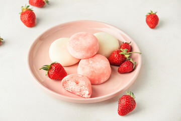 Plate with tasty Japanese mochi and strawberry on light background