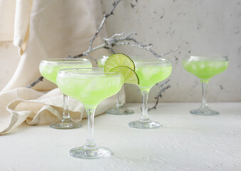 Glasses with tasty daiquiri cocktail on light background