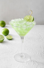 Glass with tasty daiquiri cocktail on light background