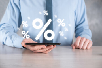 Male hand holding interest rate percent icon on blue background. Interest rate financial and mortgage rates concept.Banner with copy space