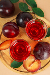Plum brandy shots and ingredients on beige background