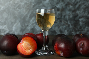 Plum vodka shot and ingredients on wooden table