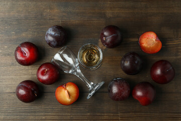 Plum vodka shot and ingredients on wooden table