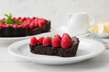 Plate with piece of tasty raspberry pie on light wooden table, closeup