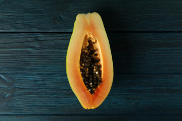 Half of papaya on dark blue wooden background