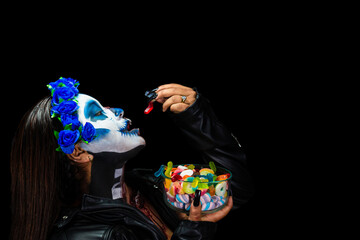 Halloween Catrina Zombie Eating colored sweets. Halloween costume and makeup.
