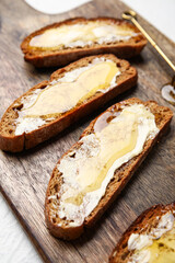 Tasty toasted bread with butter honey on table, closeup