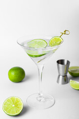 Glass of tasty gin and tonic on light background