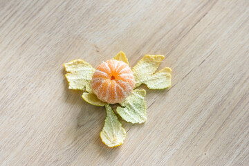 Peeled tangerines are placed on a wooden table.