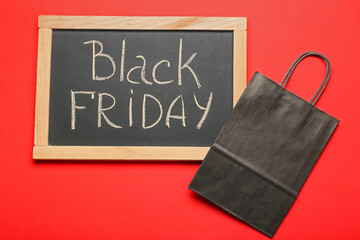 Chalkboard with text BLACK FRIDAY and shopping bag on color background