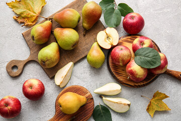 Wooden boards with ripe pears and apples on light background