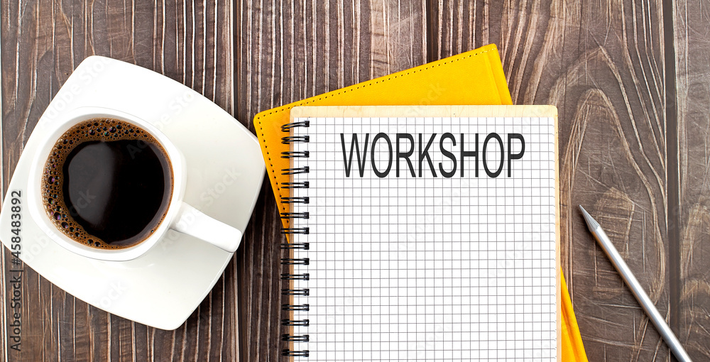 Poster workshop text on the notebook with coffee on wooden background