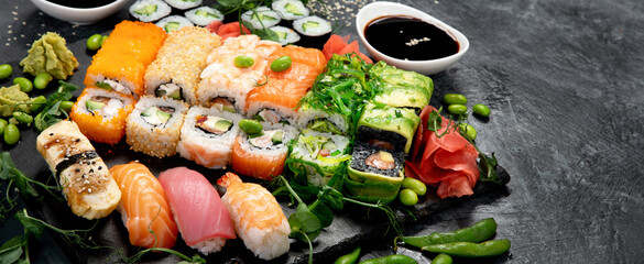 Sushi and roll set on dark background. Traditional food concept.