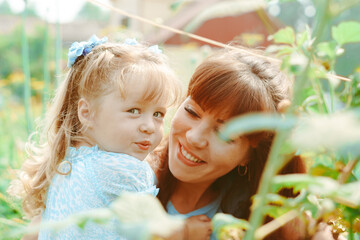 mom hugs her daughter in nature
