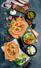 Italian food assortment on dark background.