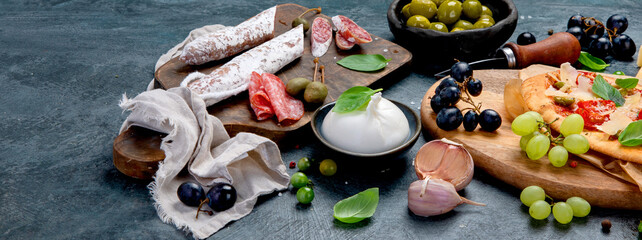 Italian food assortment on dark background.